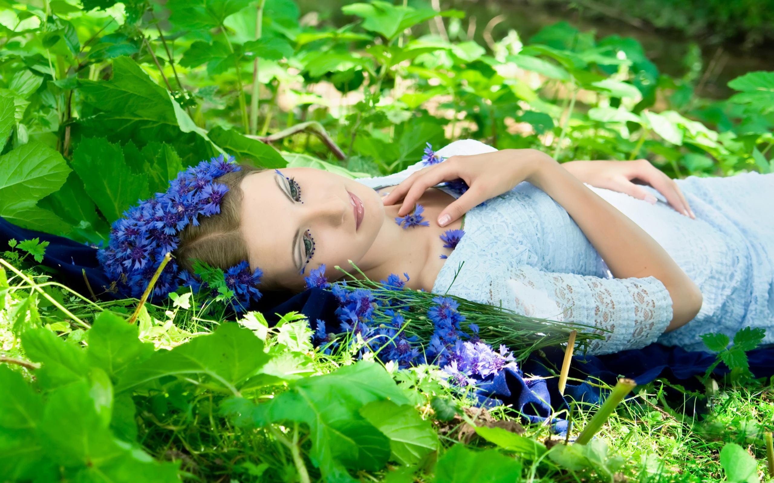 women, Model, Brunette, Face, Women outdoors, Lying on back, Nature, Flowers, Leaves, Makeup, Dress, Sunlight, Blue flowers Wallpaper