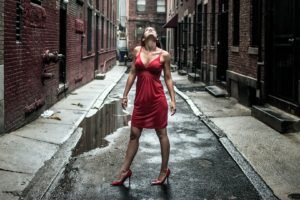 women, Model, Brunette, Long hair, Women outdoors, Red dress, Looking up, Street, Building, Bricks, Water, High heels, Stiletto, Cleavage